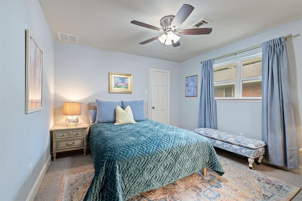 15935 Longvista Drive Dallas, TX 75248 - Photo 19 of 27 a bedroom with a bed a chandelier and a chair