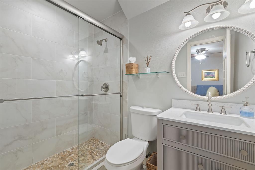 15935 Longvista Drive Dallas, TX 75248 - Photo 20 of 27 a bathroom with a sink a toilet and shower