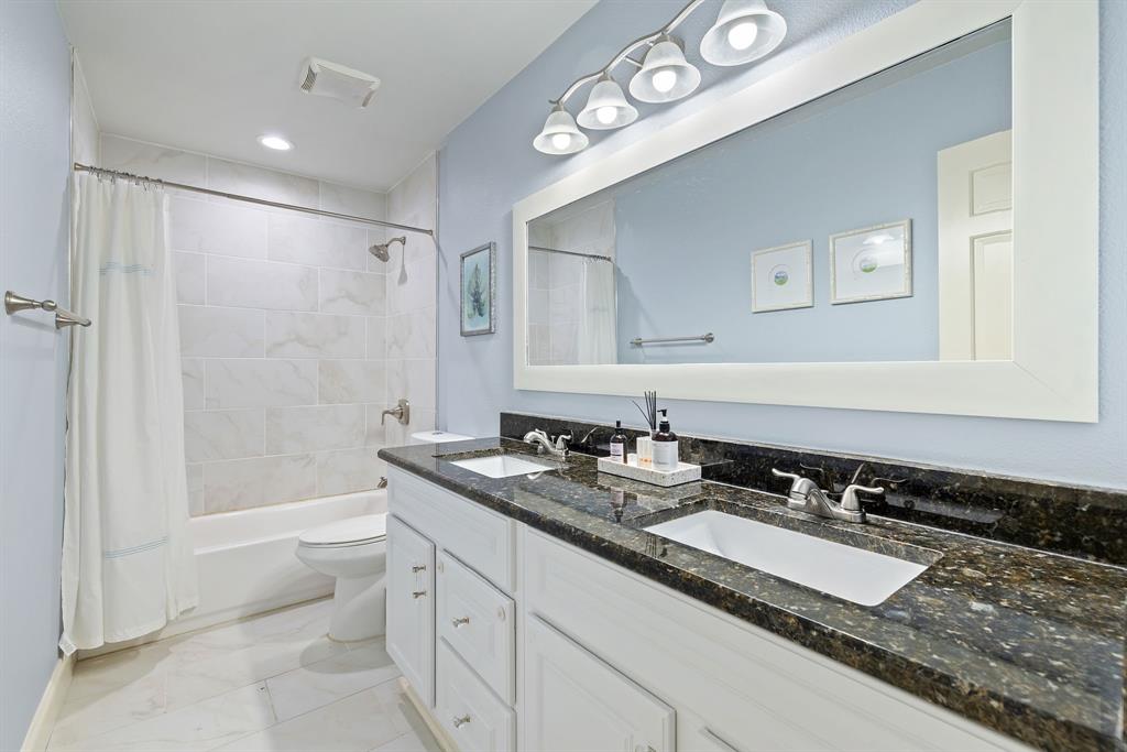 15935 Longvista Drive Dallas, TX 75248 - Photo 22 of 27 a bathroom with a granite countertop sink mirror and a bathtub