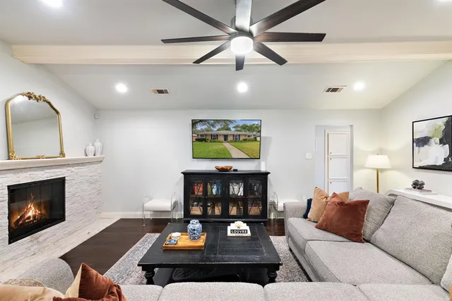a living room with furniture a fireplace and a flat screen tv