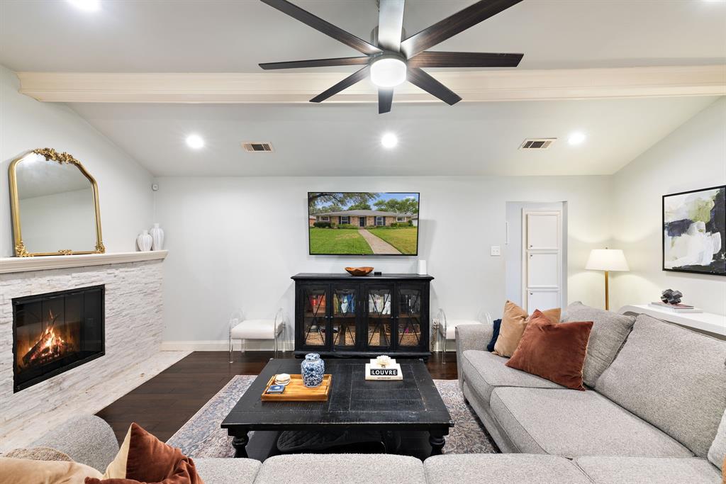 15935 Longvista Drive Dallas, TX 75248 - Photo 9 of 27 a living room with furniture a fireplace and a flat screen tv