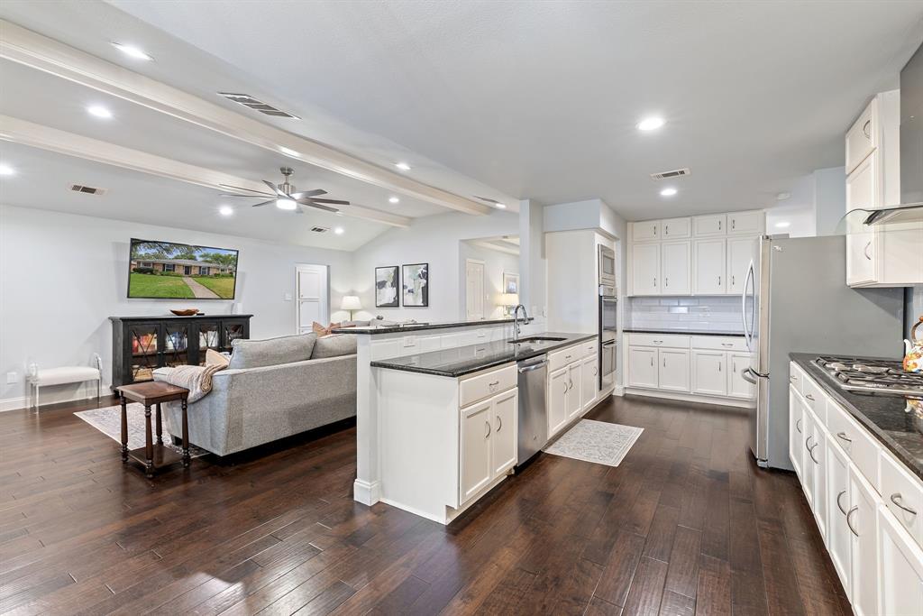15935 Longvista Drive Dallas, TX 75248 - Photo 27 of 27 a large kitchen with stainless steel appliances granite countertop a lot of counter space and wooden floors