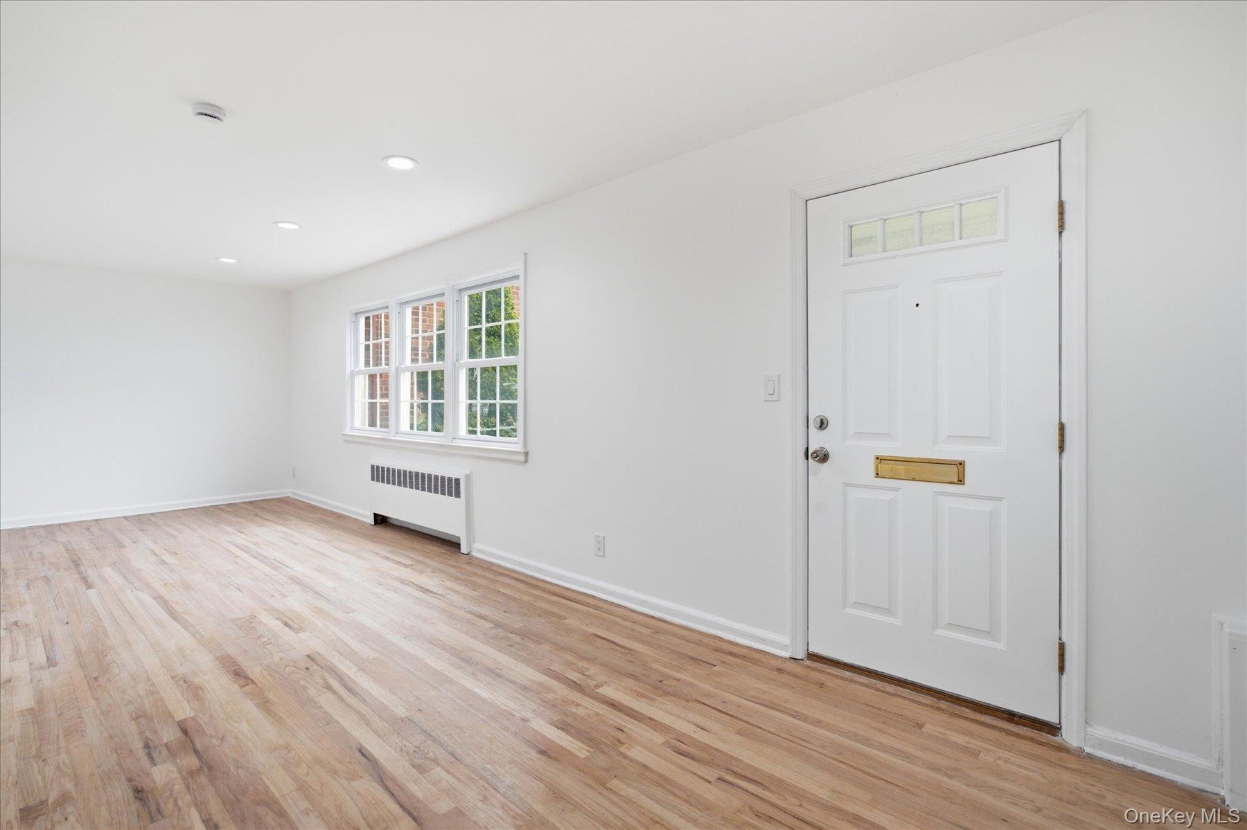 117 Robins Road, Unit 117 New Rochelle, NY 10801 - Photo 6 of 28 an empty room with wooden floor and window