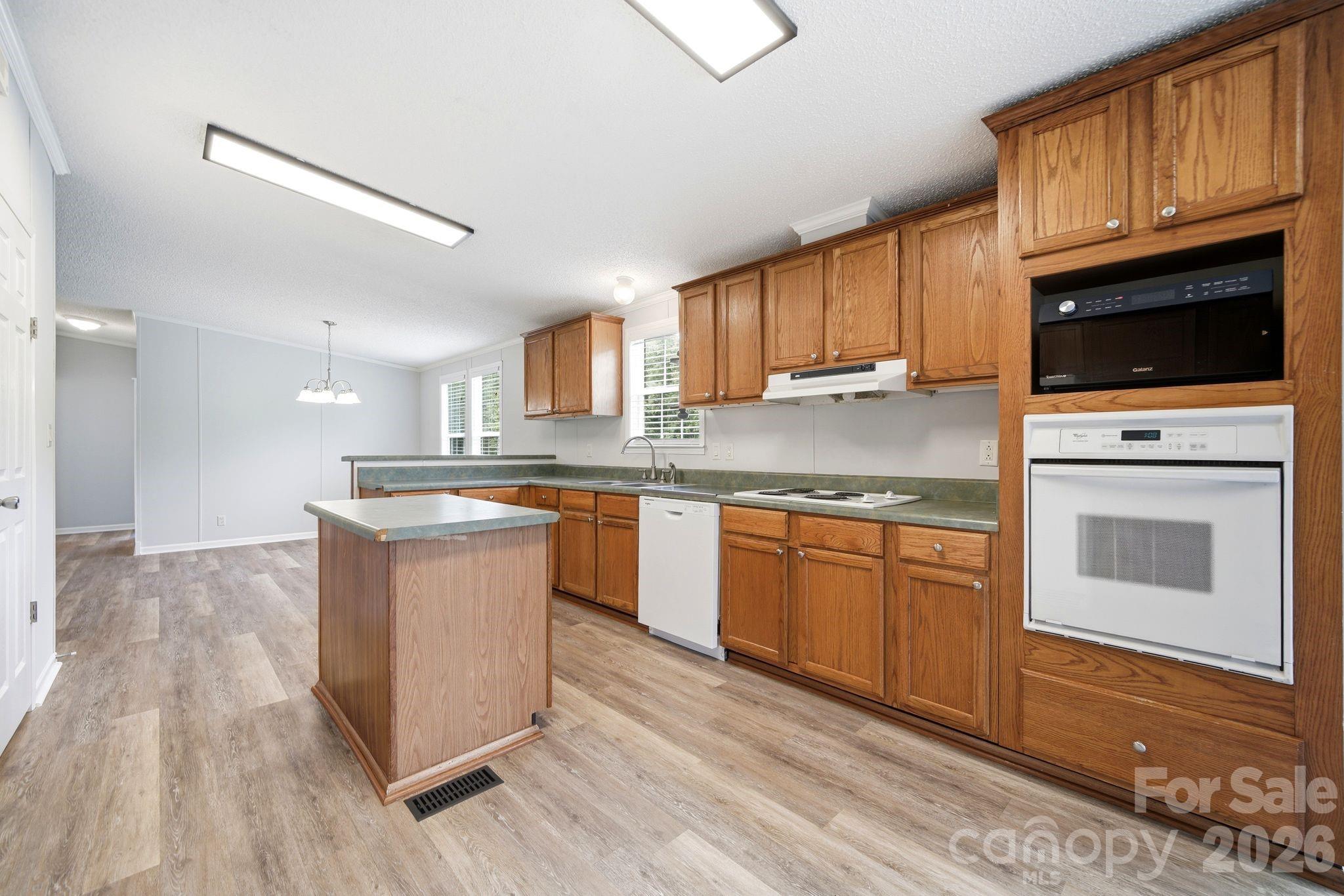 2368 Beth Haven Church Road Denver, NC 28037 - Photo 27 of 42 a kitchen with granite countertop a stove top oven sink and cabinets