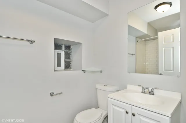 a bathroom with a toilet sink and mirror