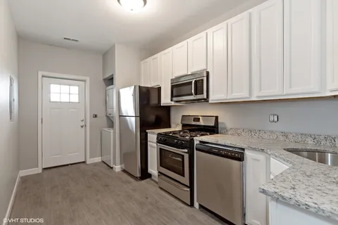 a kitchen with stainless steel appliances granite countertop a stove a refrigerator and a microwave
