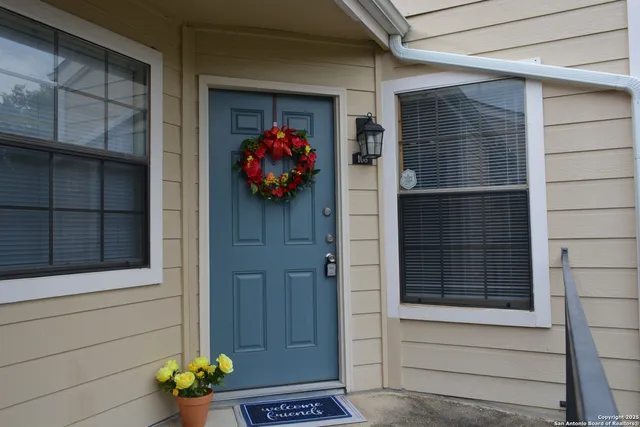 a front view of a house with a potted plant