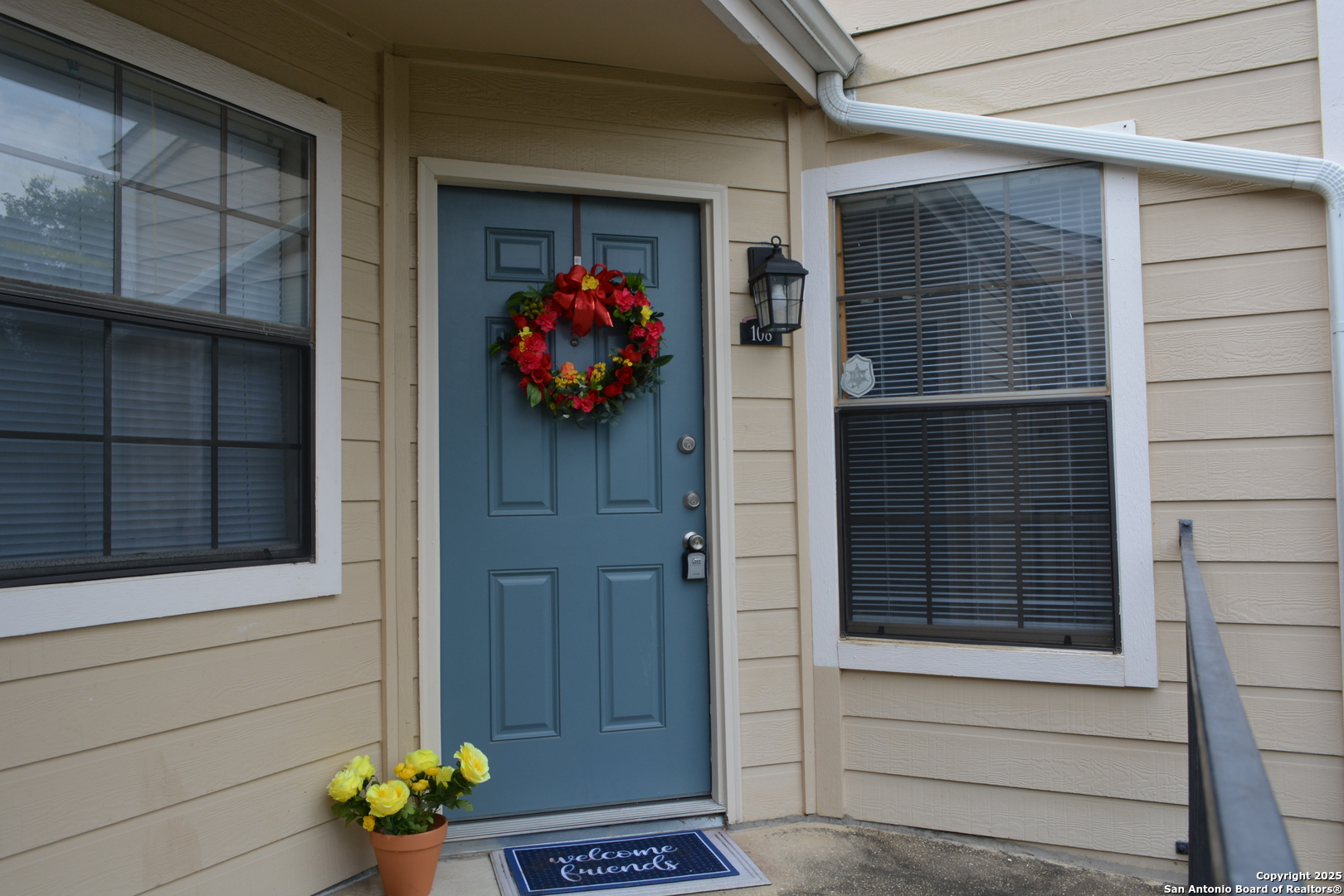 a front view of a house with a potted plant