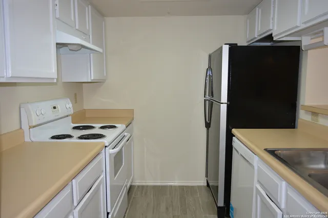 a kitchen with stainless steel appliances granite countertop a refrigerator and a stove
