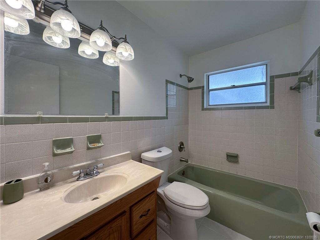 1739 Southeast Madison Street Stuart, FL 34997 - Photo 18 of 38 a bathroom with a sink mirror and toilet