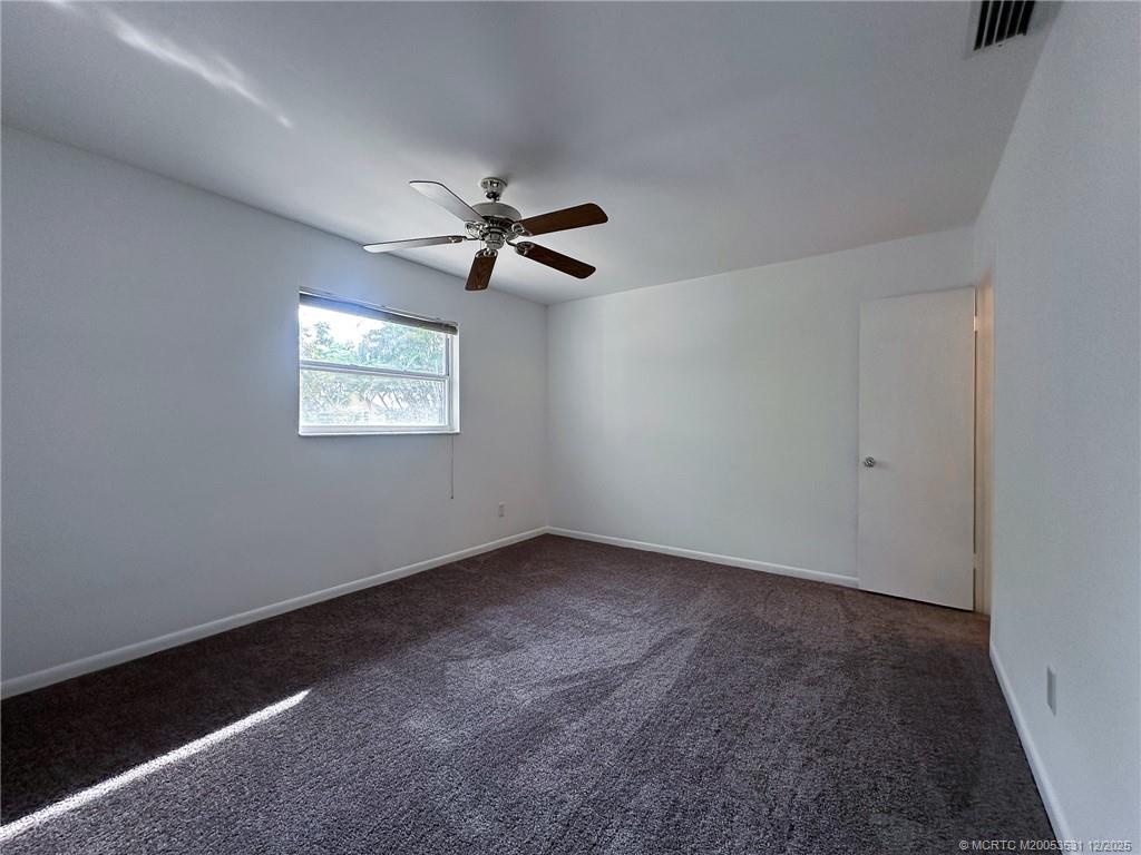 1739 Southeast Madison Street Stuart, FL 34997 - Photo 20 of 38 en empty room with windows and ceiling fan