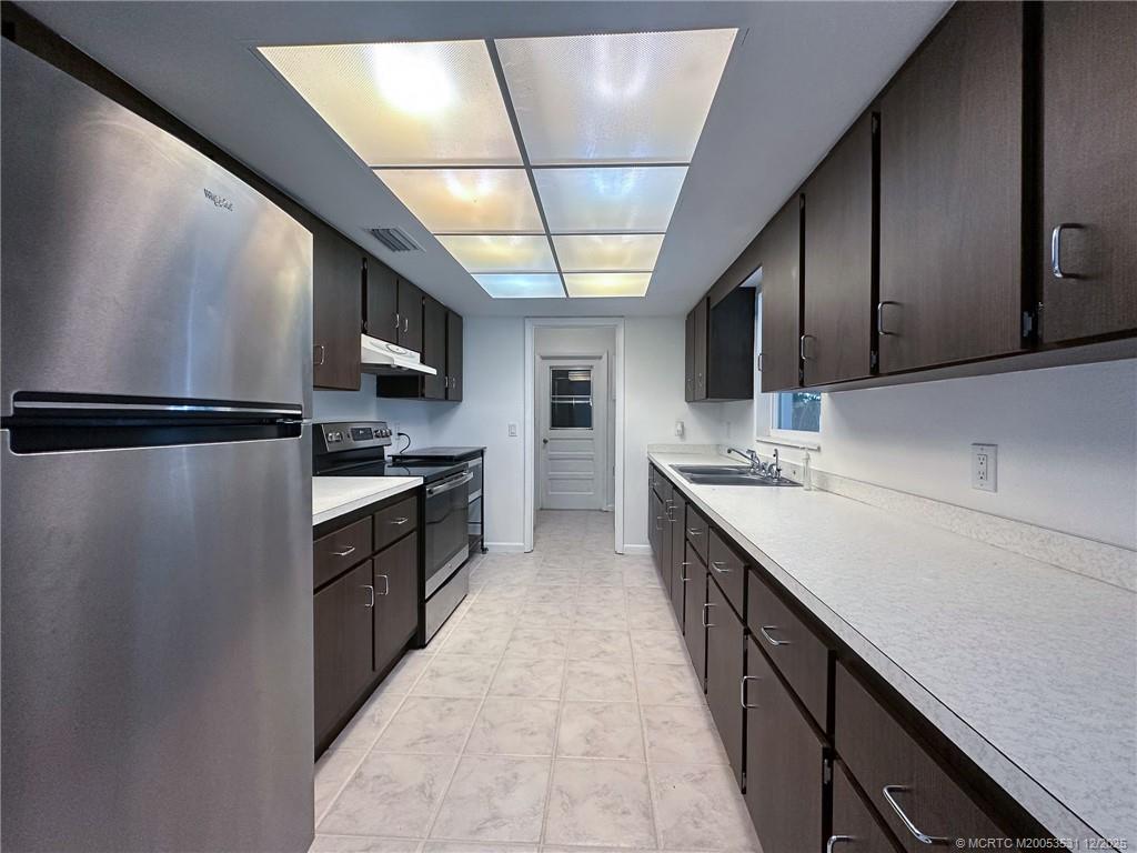 1739 Southeast Madison Street Stuart, FL 34997 - Photo 24 of 38 a kitchen with stainless steel appliances sink refrigerator and microwave