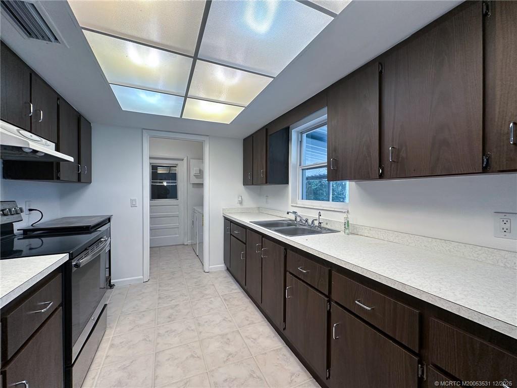 1739 Southeast Madison Street Stuart, FL 34997 - Photo 25 of 38 a kitchen with stainless steel appliances granite countertop a sink stove and refrigerator