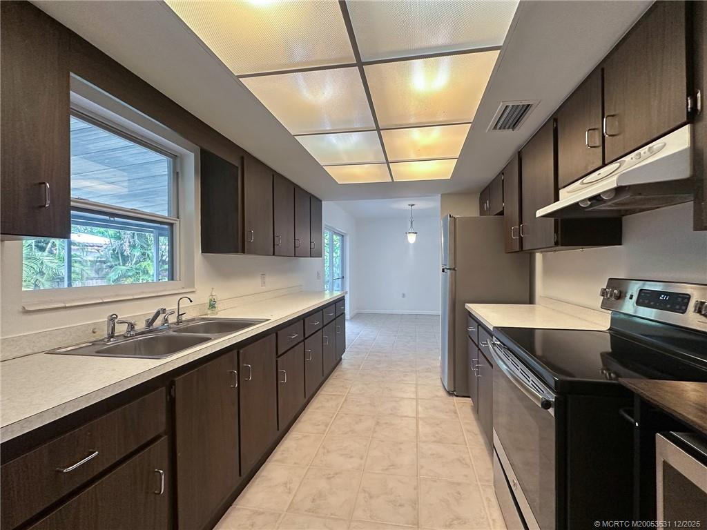 1739 Southeast Madison Street Stuart, FL 34997 - Photo 26 of 38 a kitchen with a sink stove and cabinets