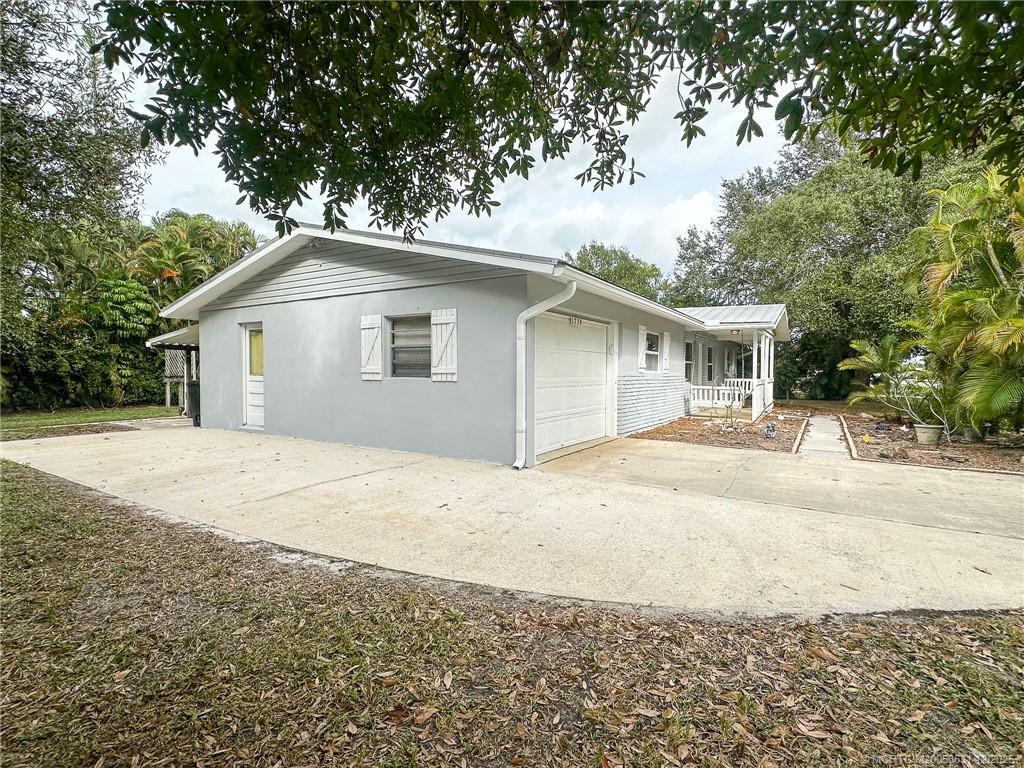 1739 Southeast Madison Street Stuart, FL 34997 - Photo 38 of 38 a front view of a house with a yard and garage