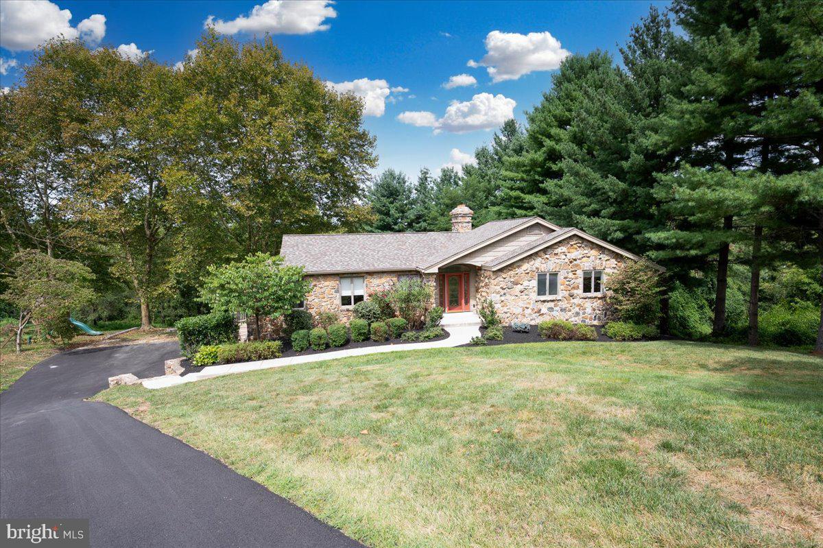 a view of a house with a yard and large tree