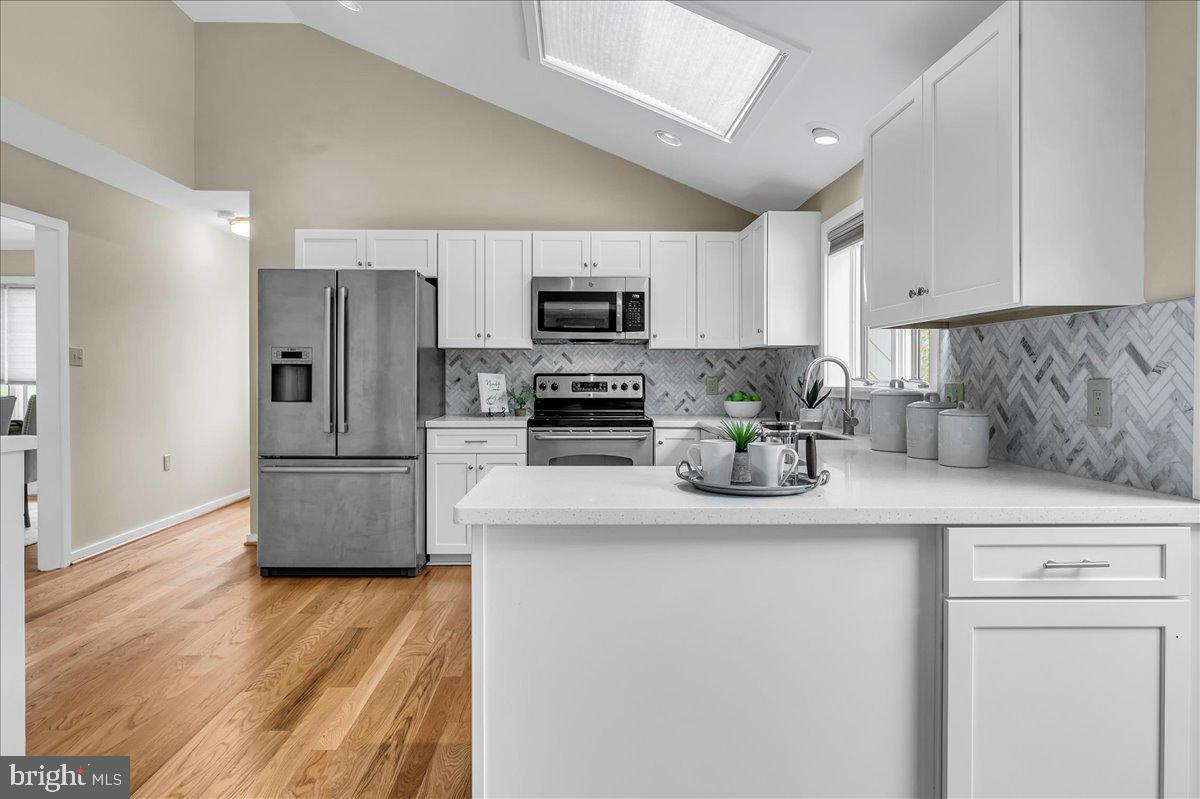 977 Wind Song Road West Chester, PA 19382 - Photo 12 of 57 a kitchen with stainless steel appliances granite countertop a refrigerator a stove a sink a microwave and wooden cabinets