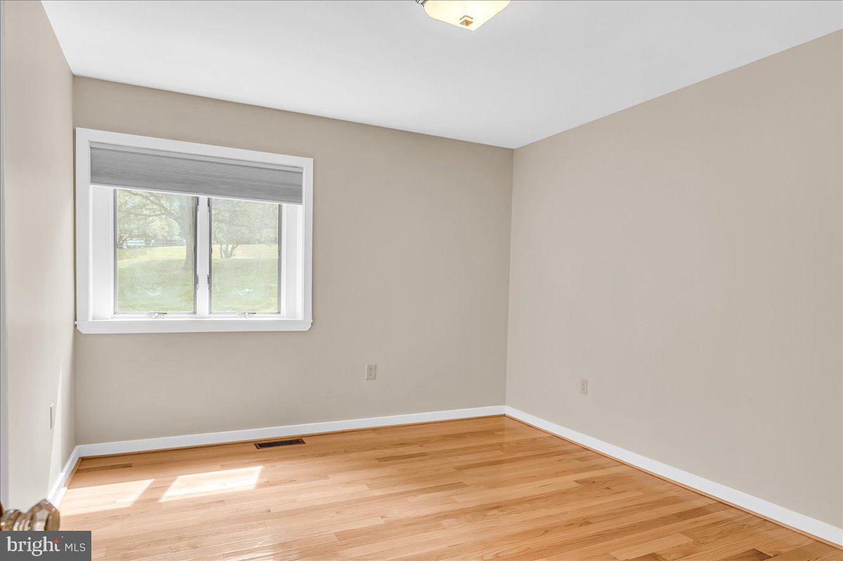 977 Wind Song Road West Chester, PA 19382 - Photo 32 of 57 a view of an empty room with wooden floor and a window