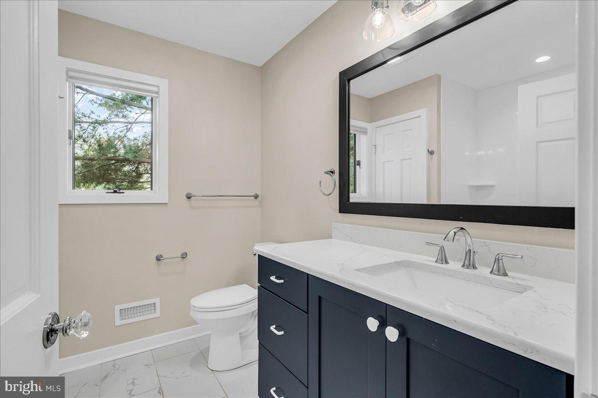 977 Wind Song Road West Chester, PA 19382 - Photo 35 of 57 a bathroom with a toilet a sink a mirror and a window