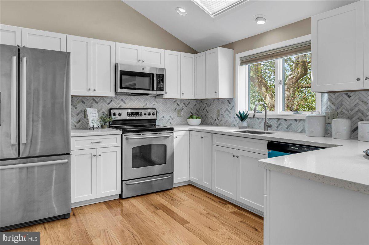 977 Wind Song Road West Chester, PA 19382 - Photo 9 of 57 a kitchen with white cabinets stainless steel appliances and window