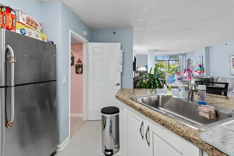a kitchen with stainless steel appliances granite countertop a refrigerator and a sink