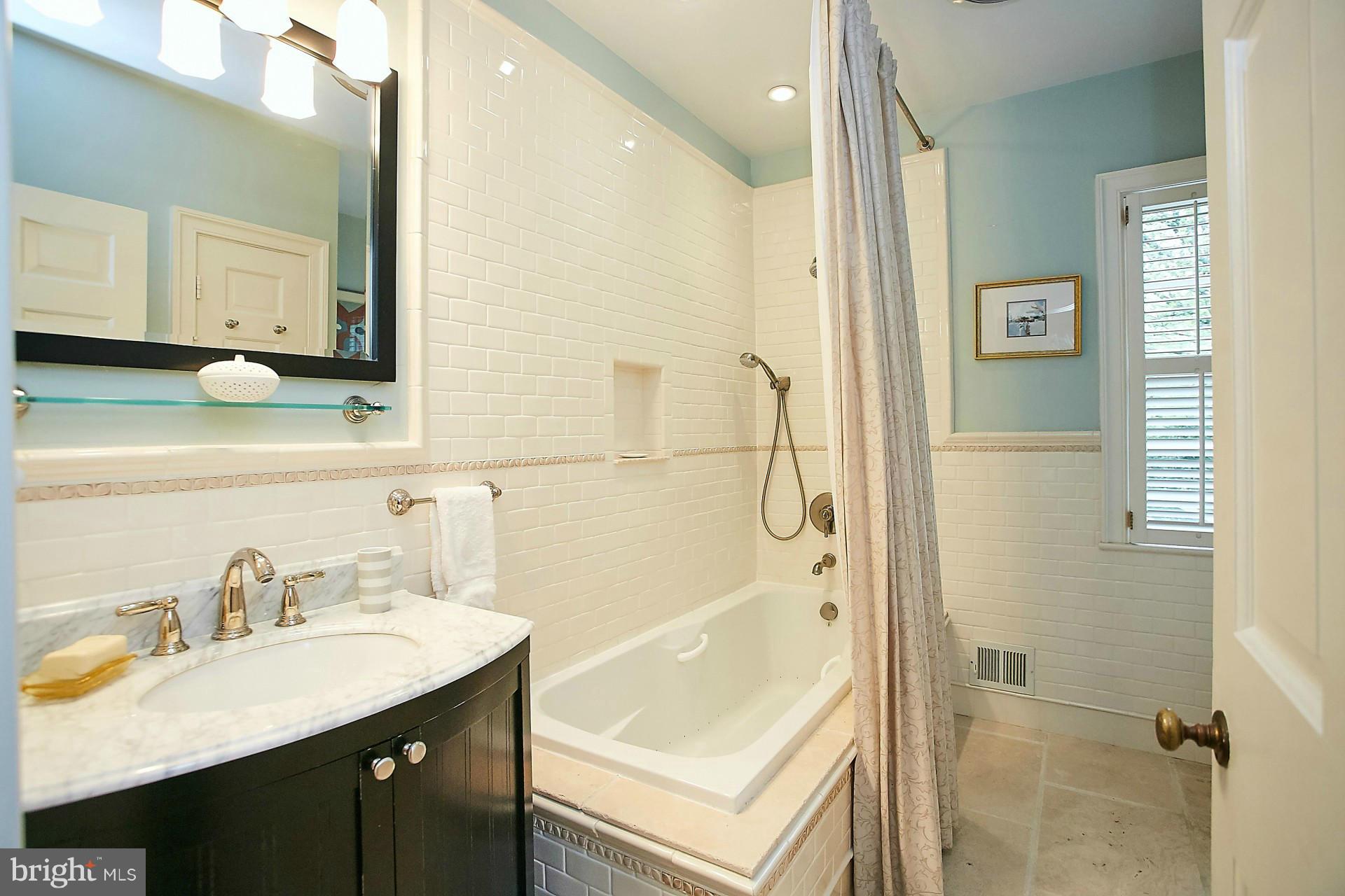 6539 Georgetown Pike McLean, VA 22101 - Photo 24 of 30 a bathroom with a tub sink and mirror