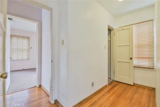 a view of a room with wooden floor and a bathroom