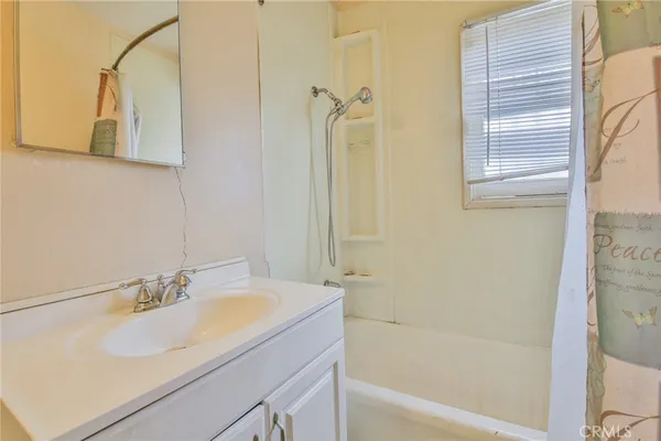 a bathroom with a granite countertop sink a mirror and a bathtub