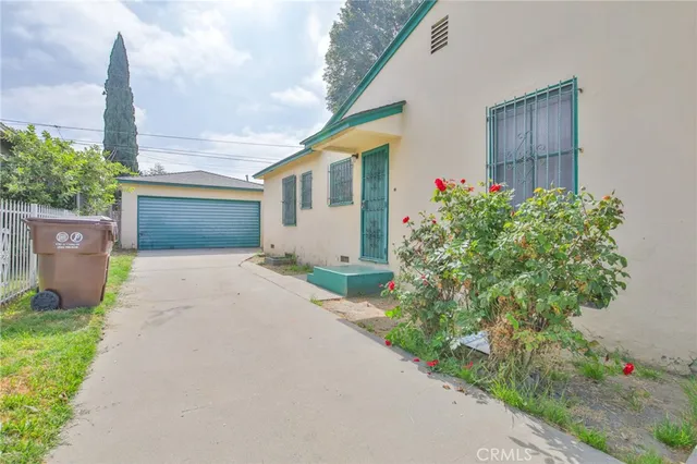 a front view of a house with a yard and potted plants