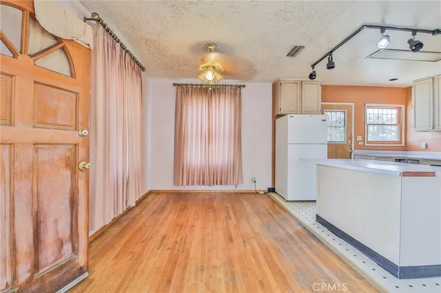 a view of a hallway with wooden floor and door