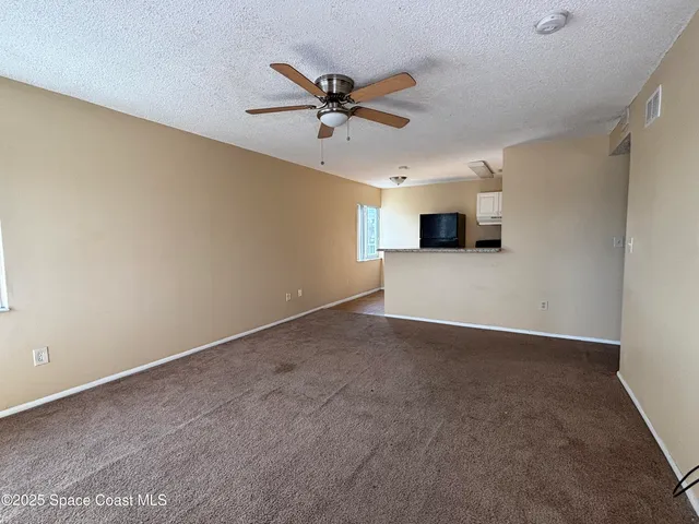 a view of a livingroom with a ceiling fan and a window