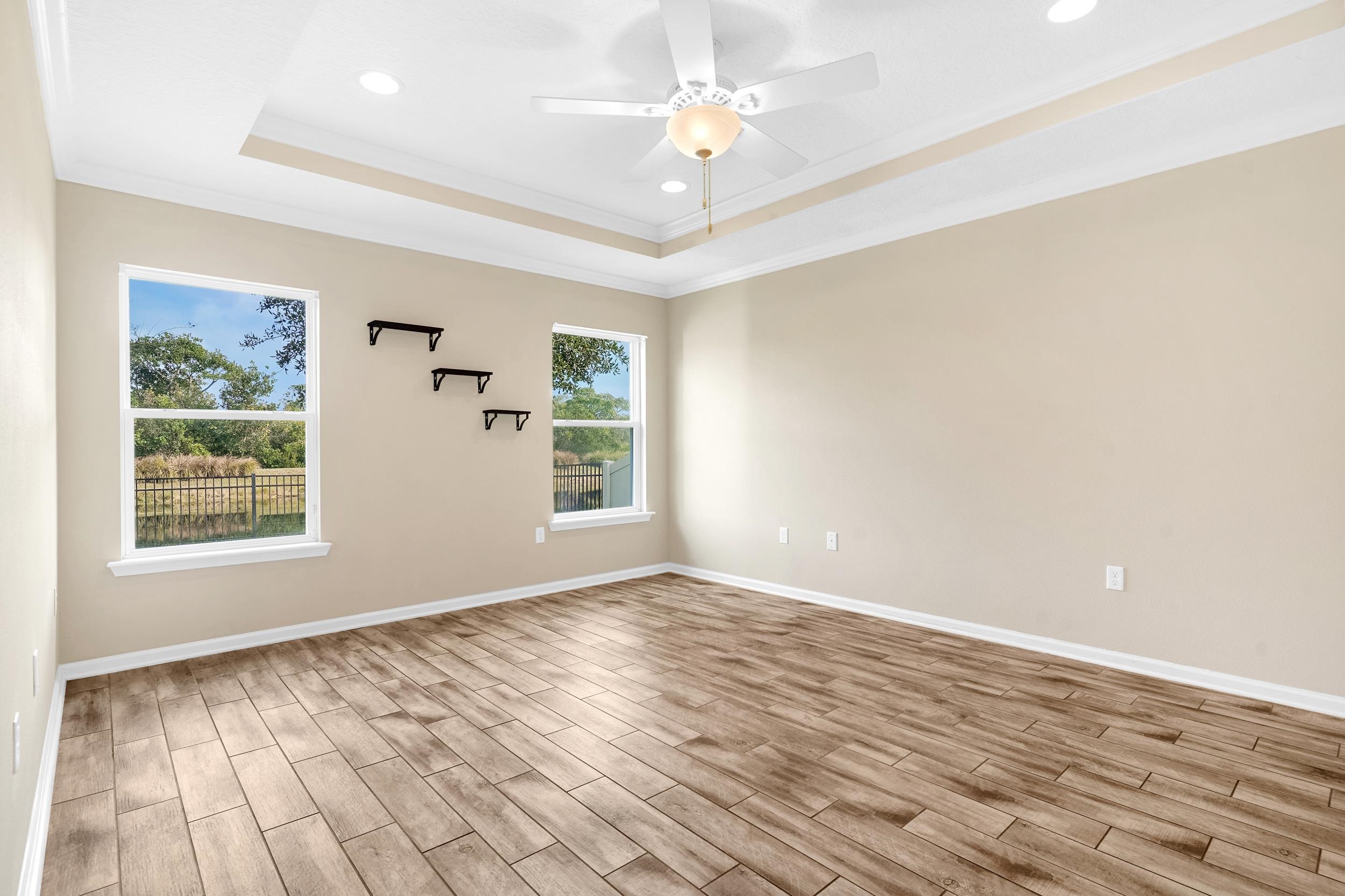 146 Ocean Cay Boulevard St. Augustine, FL 32080 - Photo 22 of 41 an empty room with wooden floor chandelier fan and windows