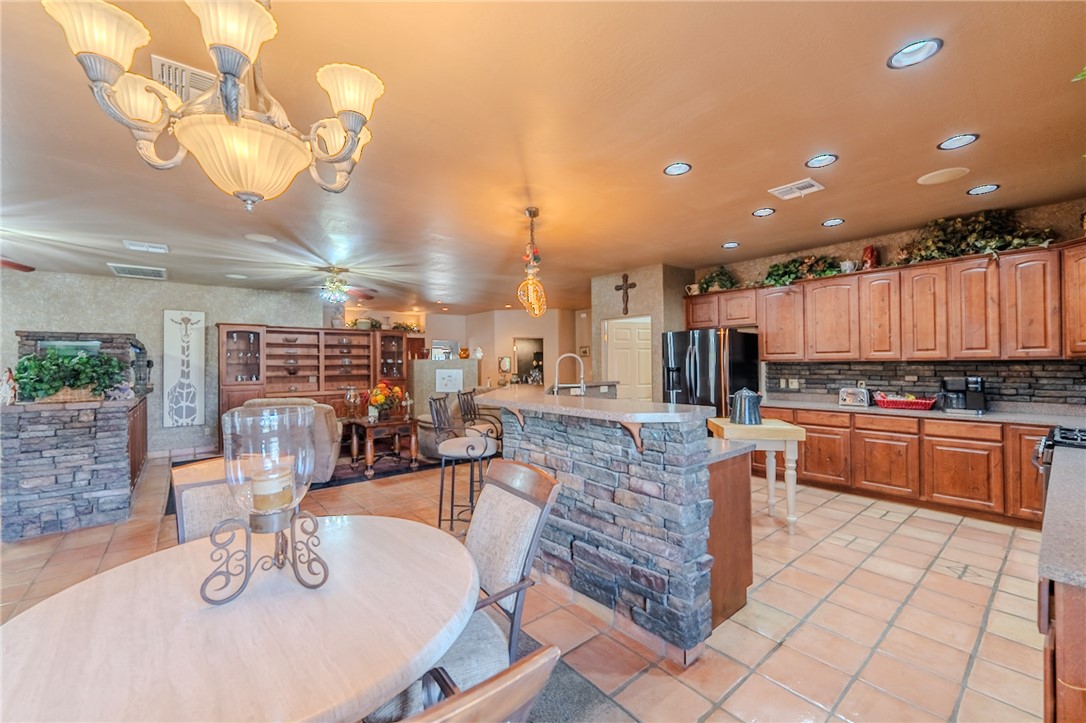 14158 Calabasas Road Yucca, AZ 86438 - Photo 43 of 99 Kitchen featuring a breakfast bar, stainless steel fridge, light tile patterned flooring, and a kitchen island with sink