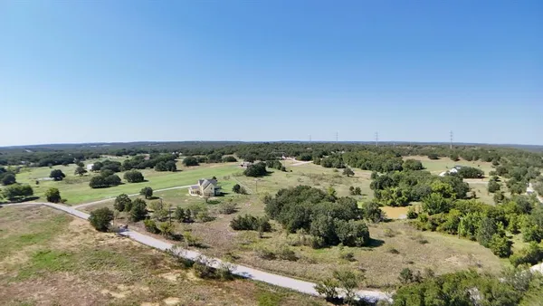 a view of a field of grass and trees