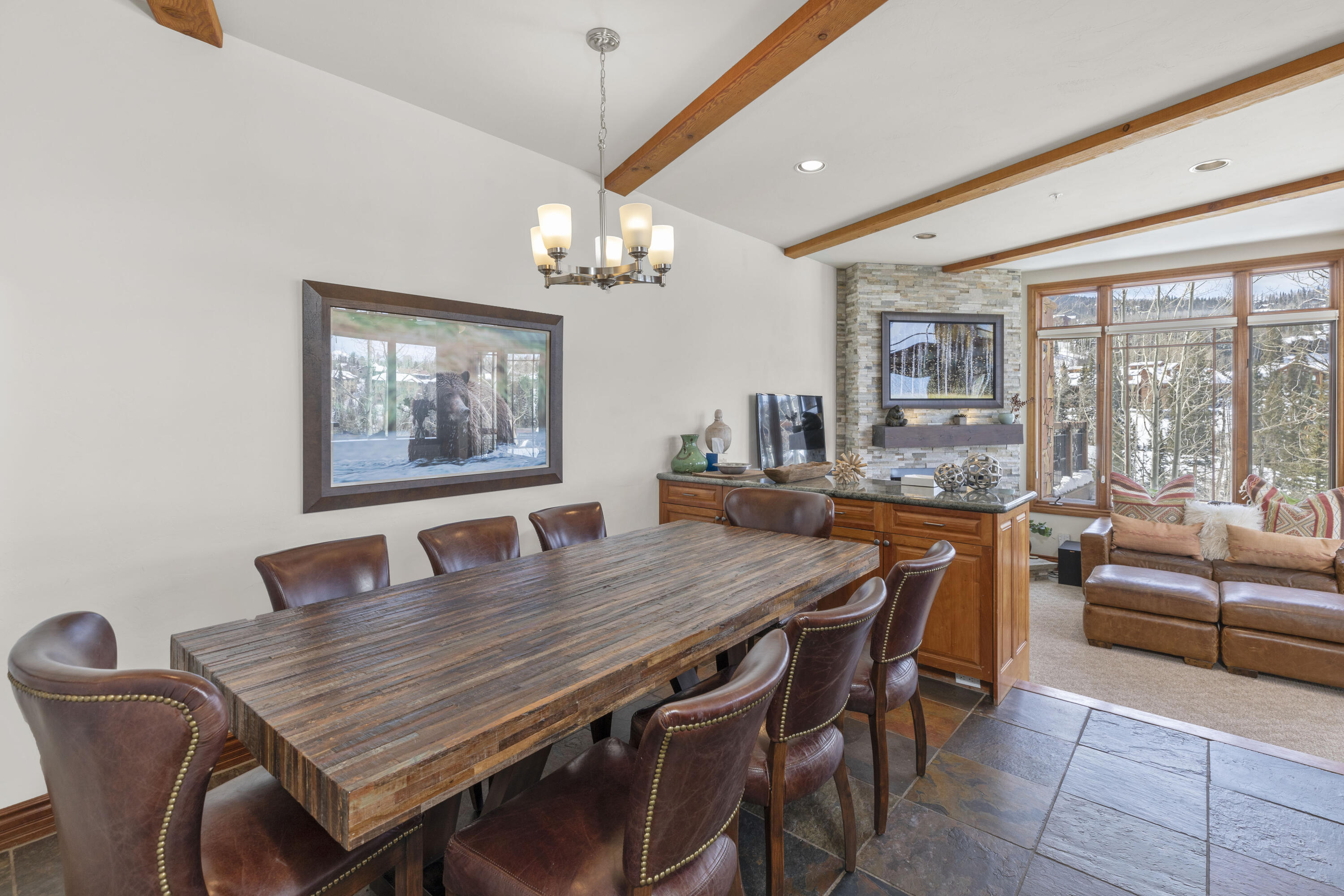 120 Vischer Drive, Unit 135 Mountain Village, CO 81435 - Photo 3 of 35 a dining room with wooden floor a chandelier a wooden table and chairs