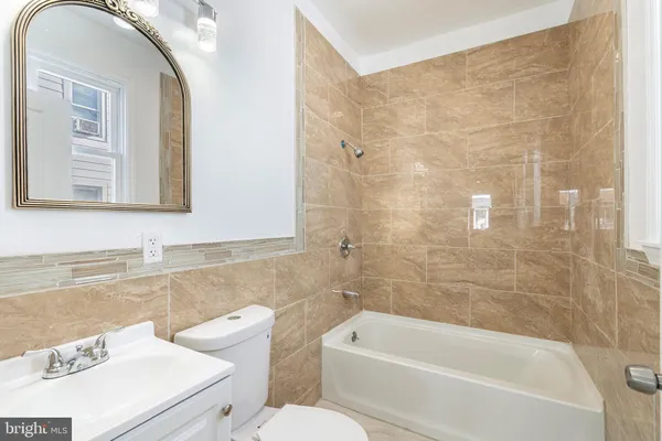 a bathroom with a sink a mirror a toilet and bathtub