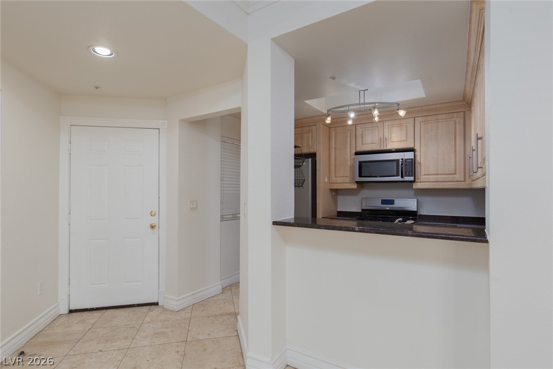 210 East Flamingo Road, Unit 117 Las Vegas, NV 89169 - Photo 11 of 24 Tile flooring leads past a raised breakfast bar opening into the kitchen.