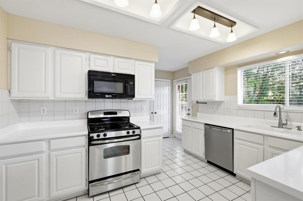 5512 Rocky Mountain Road Fort Worth, TX 76137 - Photo 14 of 33 a kitchen with granite countertop white cabinets sink and stainless steel appliances
