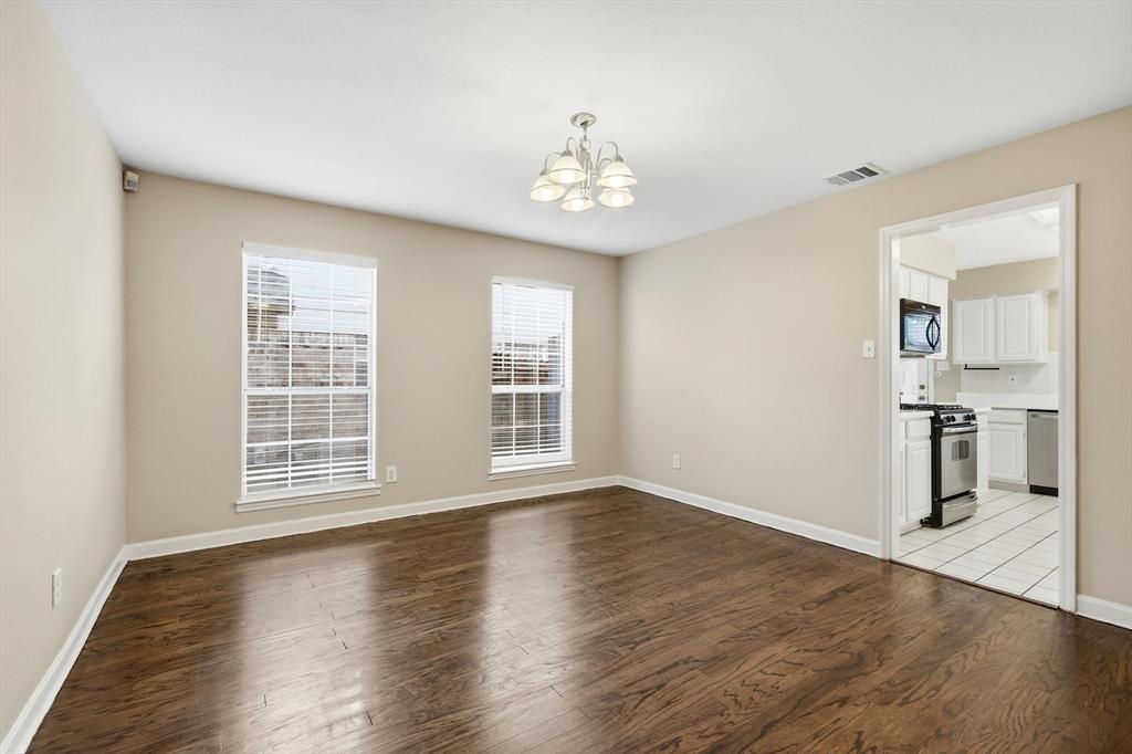 5512 Rocky Mountain Road Fort Worth, TX 76137 - Photo 17 of 33 an empty room with wooden floor staircase and windows