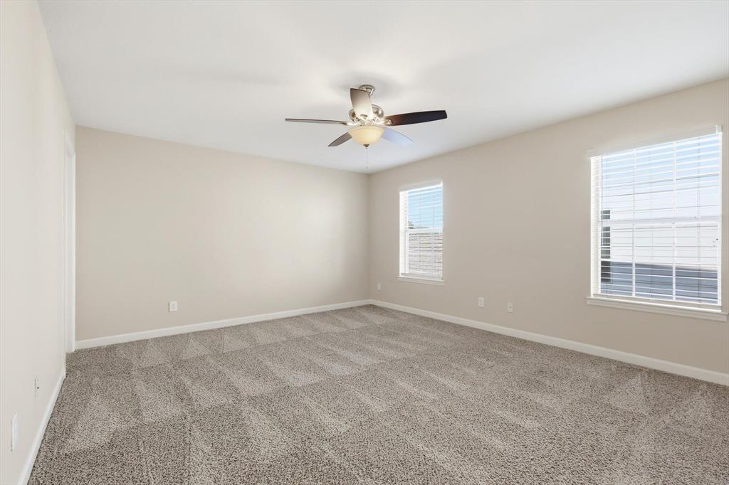 5512 Rocky Mountain Road Fort Worth, TX 76137 - Photo 18 of 33 an empty room with windows and ceiling fan