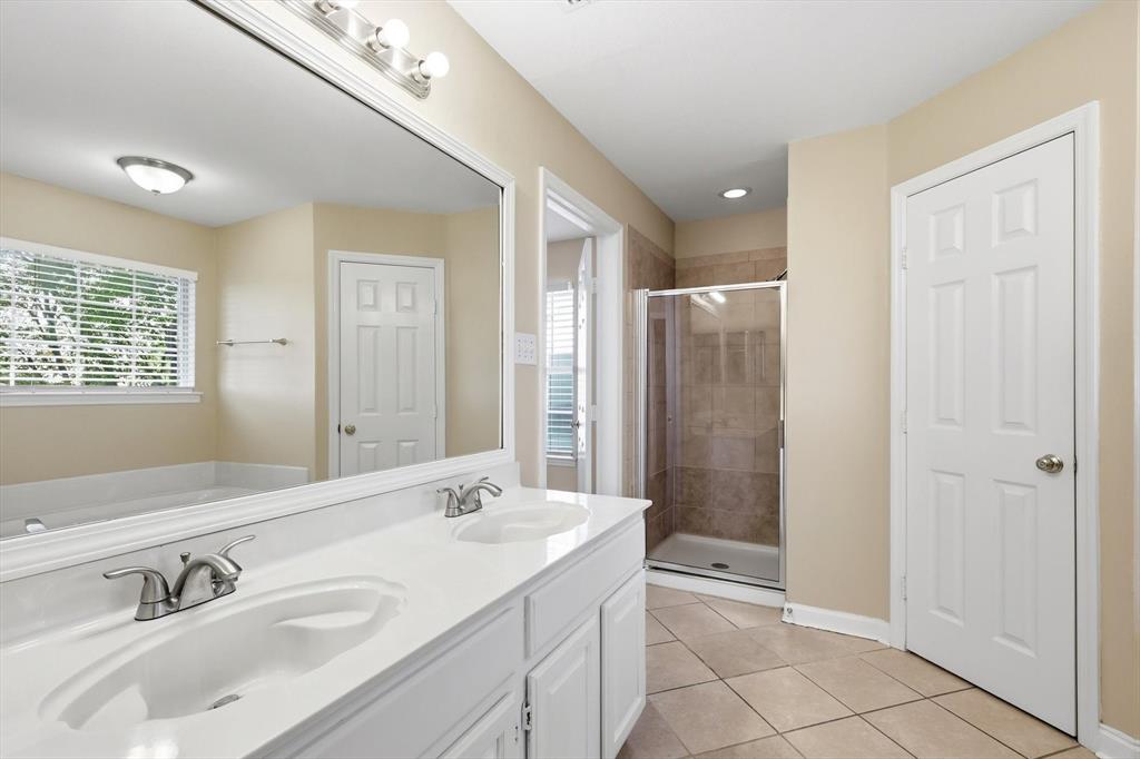 5512 Rocky Mountain Road Fort Worth, TX 76137 - Photo 21 of 33 a bathroom with a double vanity sink a mirror and a shower