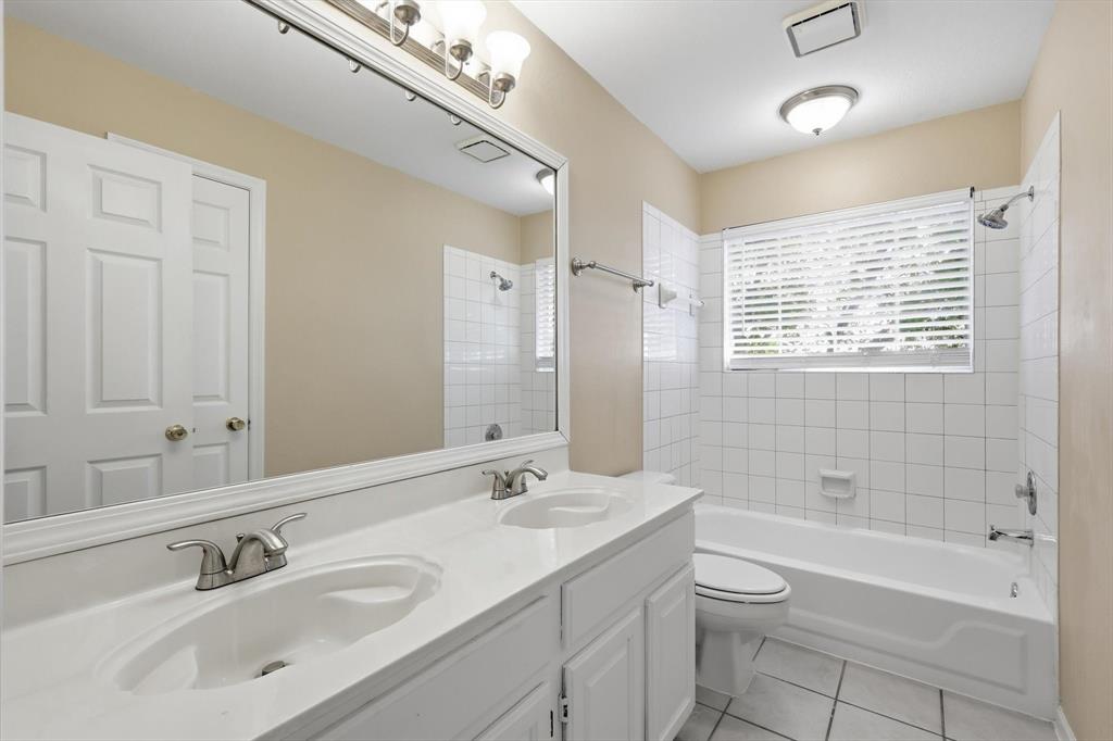 5512 Rocky Mountain Road Fort Worth, TX 76137 - Photo 23 of 33 a bathroom with a bathtub shower sink mirror vanity and a toilet
