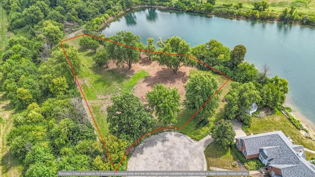 an aerial view of a house with a yard and lake view