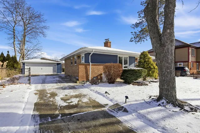 a front view of a house with a yard covered in snow