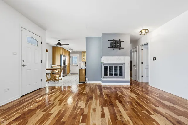 a view of a livingroom with wooden floor and furniture