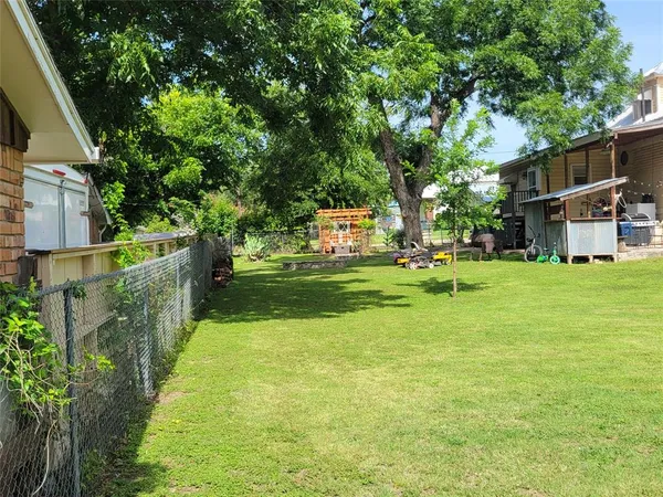 a view of a fountain in front of a house with large trees