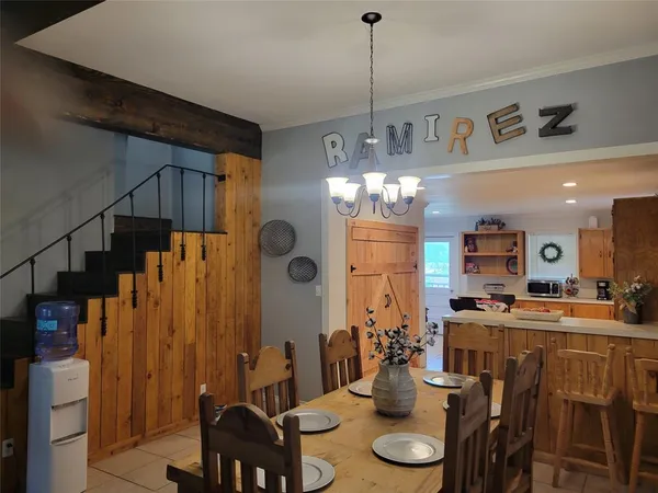 a room with stainless steel appliances kitchen island granite countertop furniture and a chandelier
