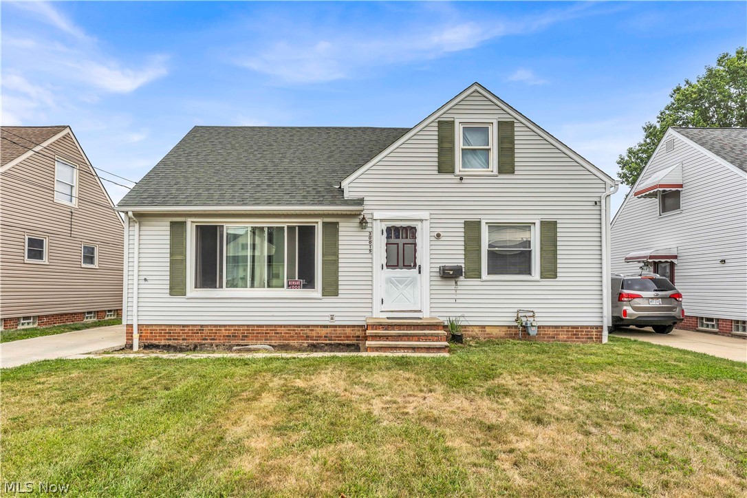 30015 Warren Road Wickliffe, OH 44092 - Photo 2 of 23 White siding exterior with a shingled roof, brick foundation, and green window shutters