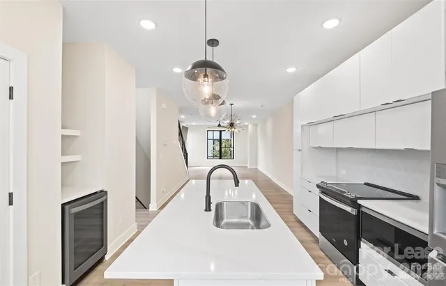 a kitchen with kitchen island stainless steel appliances a sink cabinets and wooden floor