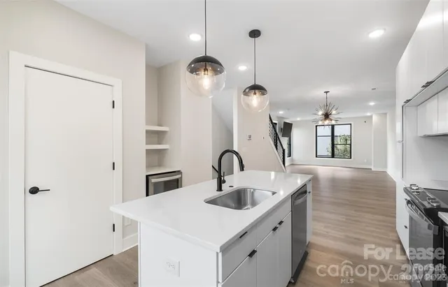 a kitchen with stainless steel appliances granite countertop a sink and a refrigerator